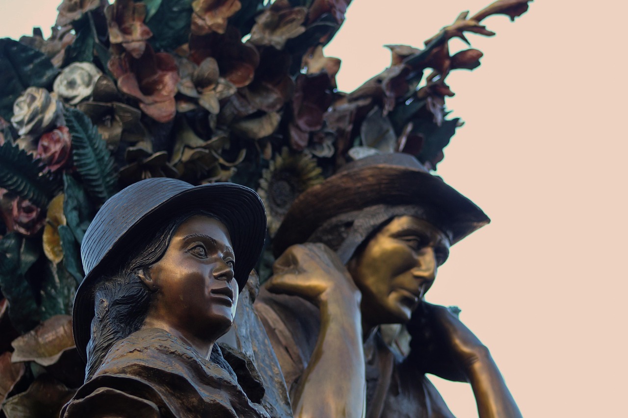 Bronze statue of silleteros carrying flower silletas, honoring the tradition behind the Desfile de Silleteros